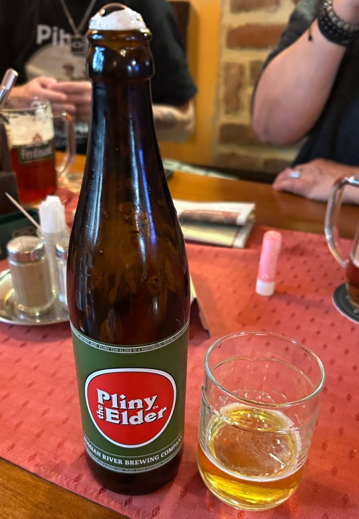 Lahev piva Pliny Elder na stole v restauraci