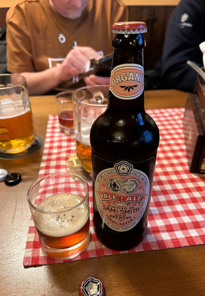 Pivo Samuel Smith Pale Ale nalité do sklenice vedle lahve