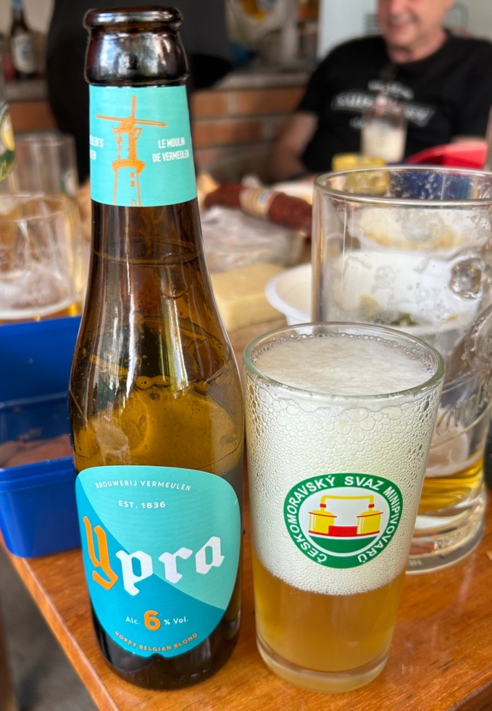 Pivo YPRA Blonde v láhvi u stolu